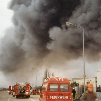 Dunkle Rauchschwaden ziehen über die zahlreichen Feuerwehrfahrzeuge.